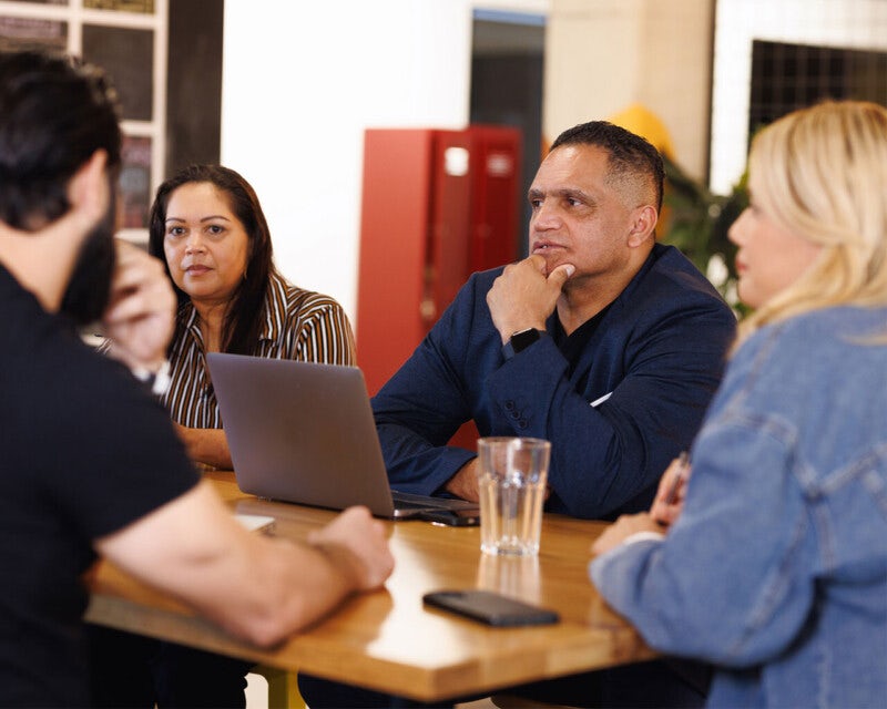 A group of colleagues meet together in a casual setting.